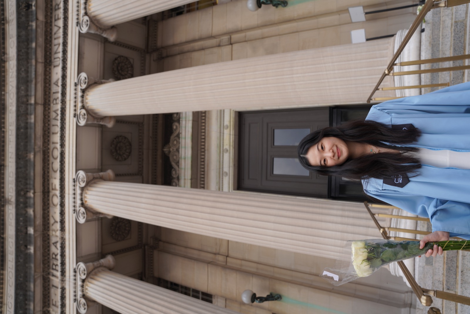 Marley in her blue Columbia graduation robe outside Butler Library